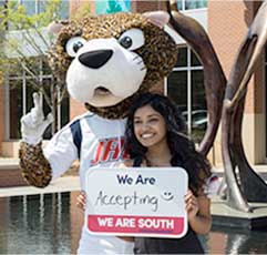 SouthPaw and a USA Student hold a sign that states: We Are Accepting