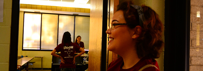 Chemistry student standing in doorway of classroom.