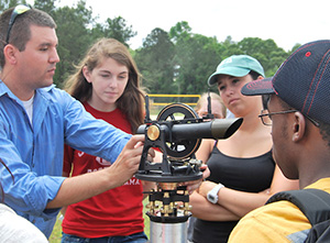 Students working wth professor outside.