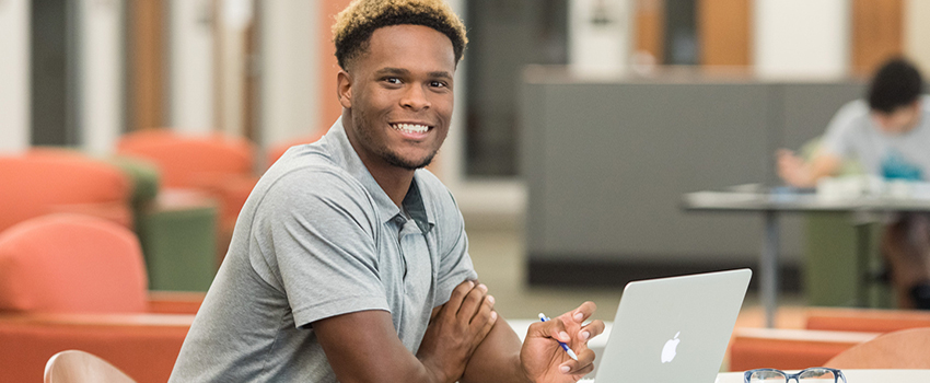 Male student working on laptop.