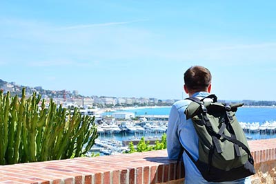 Student with backpack on looking out at the water.