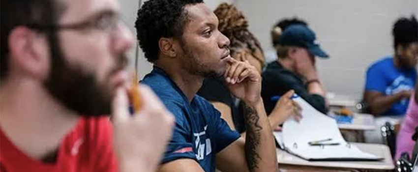 Students listening in class sitting in desks.