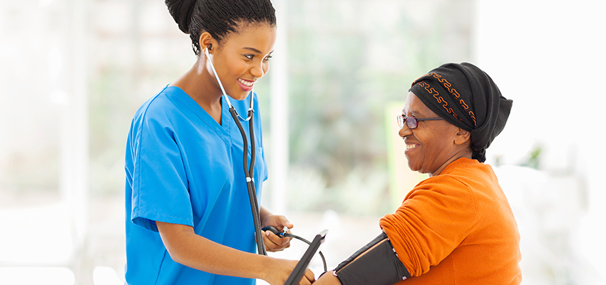 Nursing student taking blood pressure of patient.