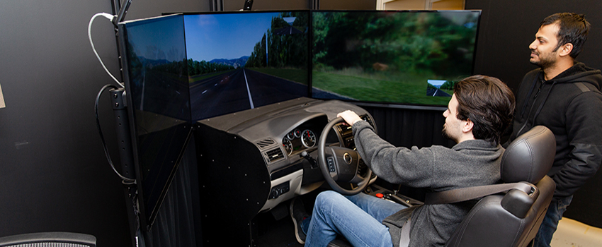 Two students working on driving simulator.