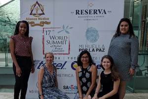 Students wth Dr. Cooke in front of world summit banner