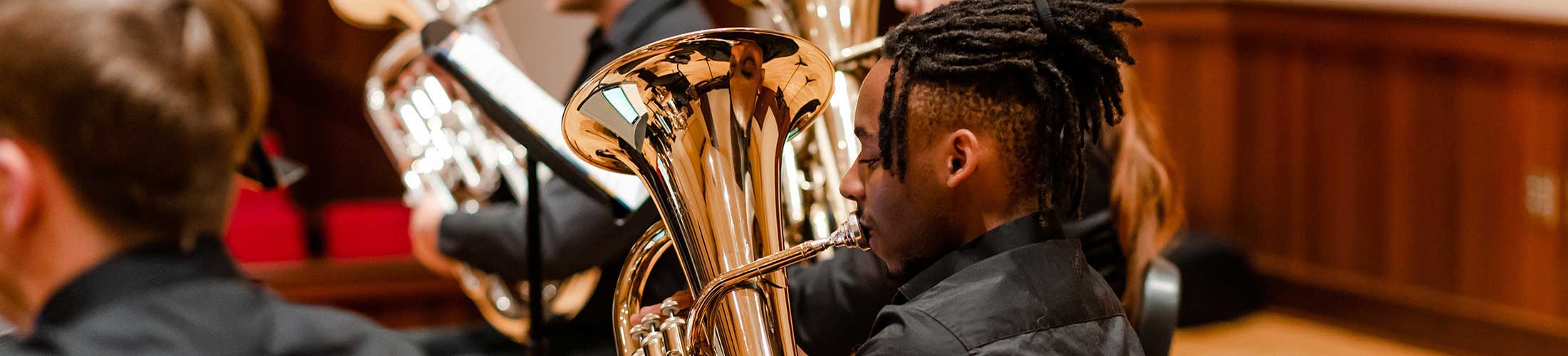 Student playing brass instrument.