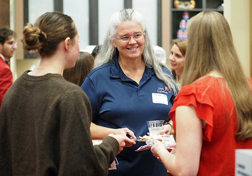Alumni speaking to young alumni at event.