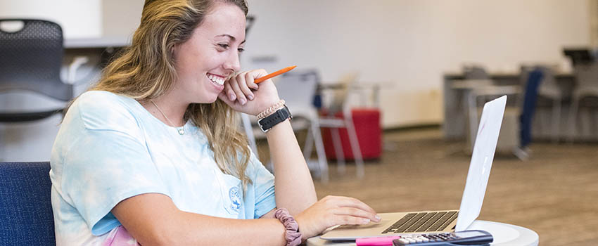 Student in Library working on laptop