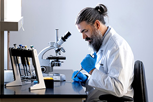 Dr. Timothy Cassell working with slide and microscope.