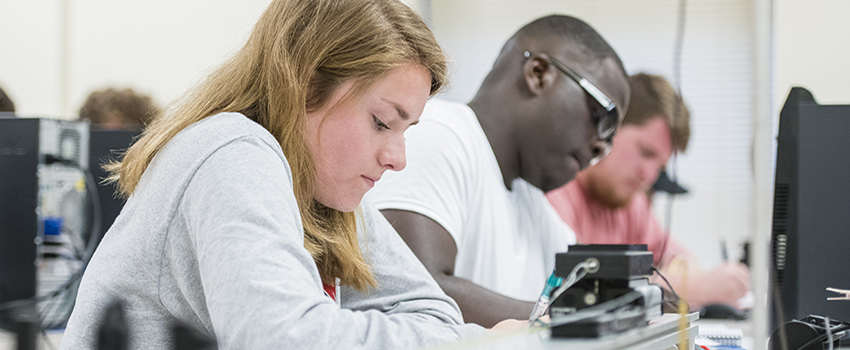 Students writing in class at desks