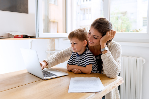 Mother with child in her lap looking at laptop