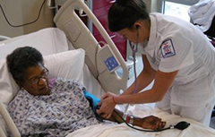 A nurse taking blood pressure of patient